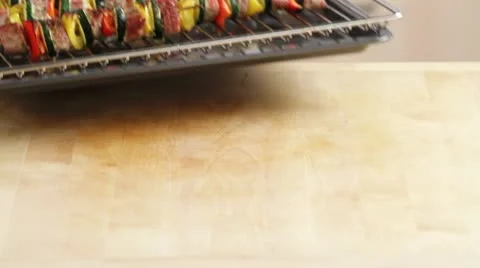 Taking grilled meat and vegetable skewers out of the oven Stock Footage 24664372