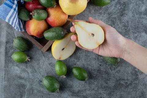 Taking a half cut pear from fruit mix tray Stock Photos
