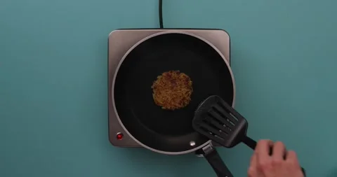 Taking the hash browns out of the pan 1 Stock Footage 132152014