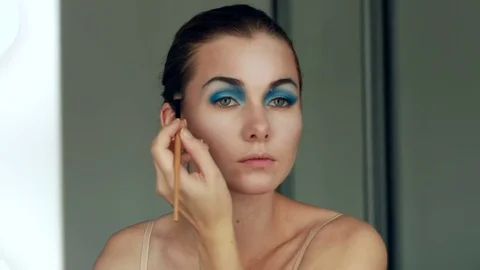 Taking off her make-up. Beautiful cheerful young woman using brush and looking Stock Footage 80622037