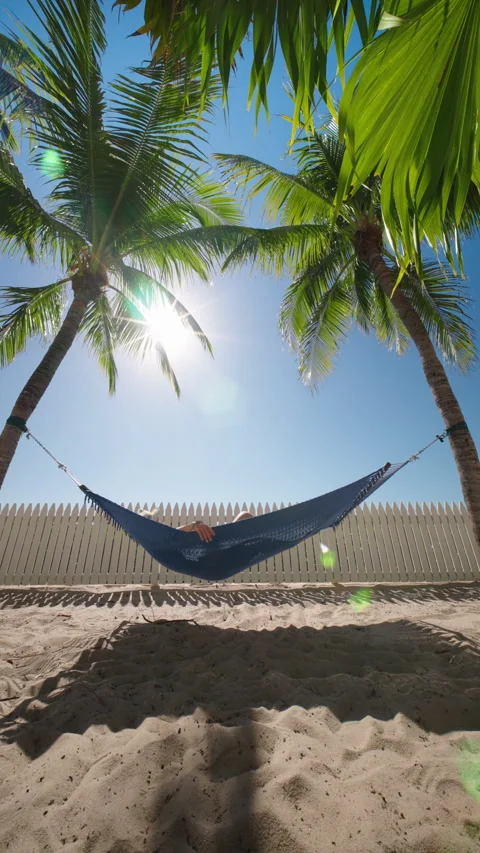 Taking it easy and enjoying a peaceful time in a tropical hammock by the beach Stock Footage 313165619