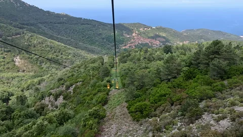 Taking the lift down the mountain. Views of the sea and mountains from above. 库存影片 329556451