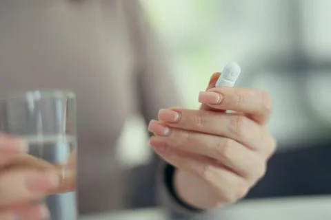 Taking Medication An InDepth Close Up View of Various Pills and Water for Stock Photos