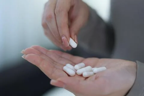 Taking Medication An InDepth Close Up View of Various Pills and Water for Stock Photos