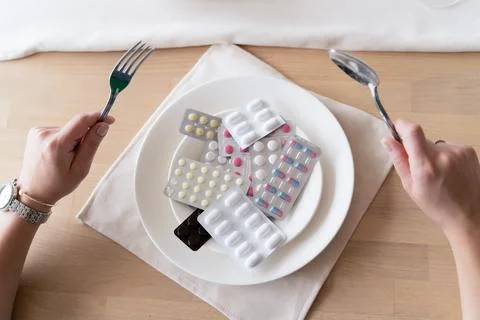 Taking medication. Tablets instead of food. Concept of vitamins instead of food Stock Photos