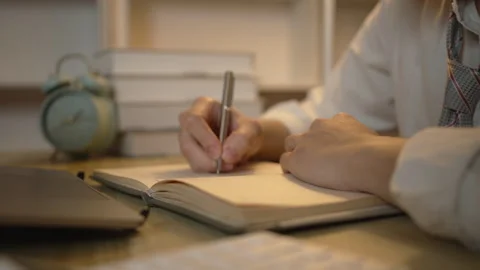 Taking note, Young Man's Hand Writing an Important Message in Notebook, Take Stockbeeldmateriaal 257159660