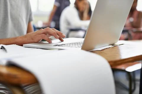 Taking notes during a lecture. Cropped shot of a male student typing during c Foto stock