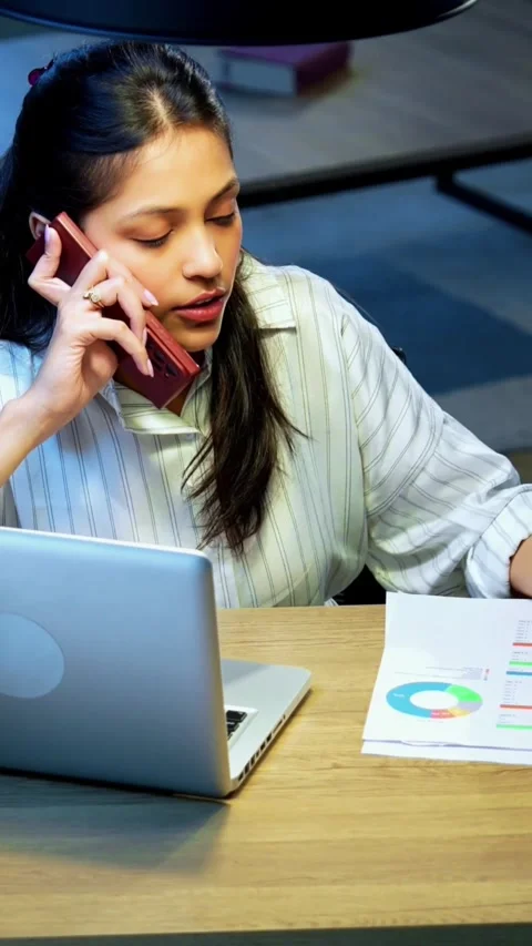 Taking notes on phone call, Indian businesswoman multitasks at desk Stock Footage 342572772
