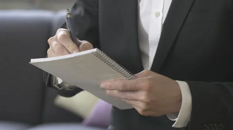 Taking notes on spiral bound paper pad Stock Footage 64402753