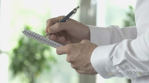 Taking notes on spiral bound paper pad Stock Footage 64402870