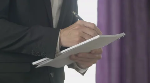 Taking notes on spiral bound paper pad Stock Footage 64450934