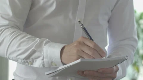 Taking notes on spiral bound paper pad Stock Footage 64450945