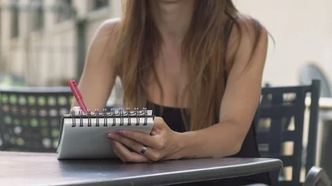 Taking notes, studying, Young woman writing on Block notes-outdoor Stock Footage 96331055