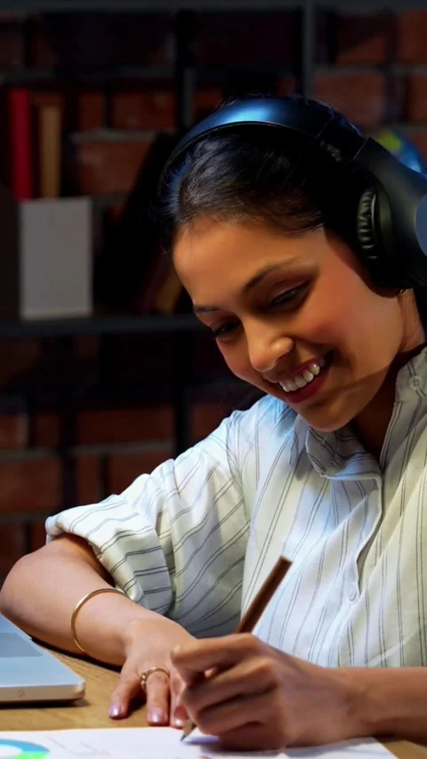 Taking notes from video call, Indian businesswoman uses headphone Stock Footage 342572794