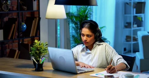 Taking notes from video call, Indian businesswoman uses headphone Stock Footage 342573533