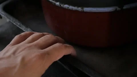 Taking old pottery from the kitchen stove slow-mo video Stock Footage 141009202