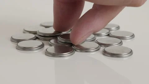 Taking one button battery from many close-up 4K video Stock Footage 98983585