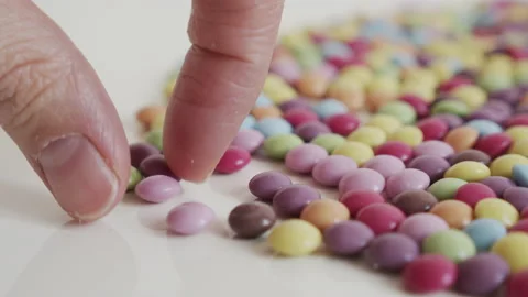 Taking one glazed button shaped candy 4K video Video stock 153240070