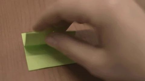 Taking one green sticky note and placing it on table, moving notes Stock Footage 100012745