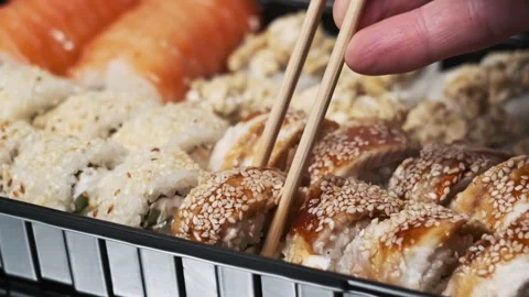 Taking One Sushi Roll From Set Using Sticks For Sushi, Close-Up Stock Footage 252568022