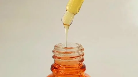 Taking out bottle pipette dropper and dripping sticky liquid vitamin c serum Stock Footage 284535250