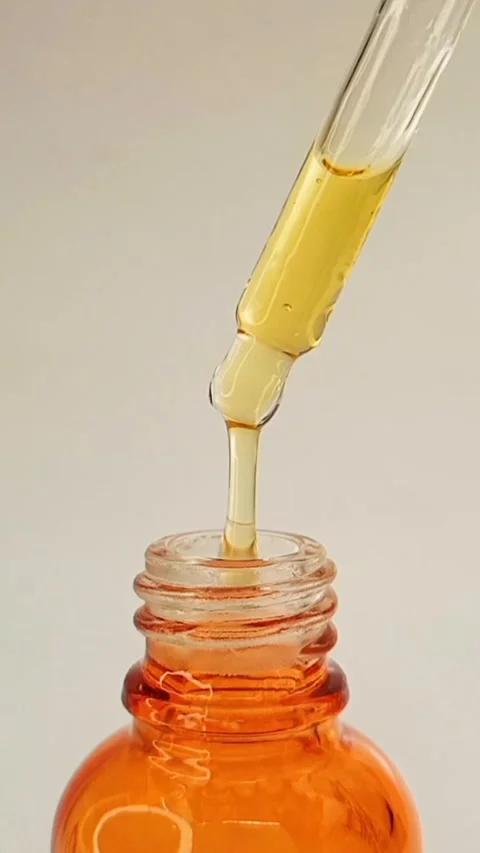 Taking out bottle pipette dropper and dripping sticky liquid yellow-orange serum Stock Footage 284535545
