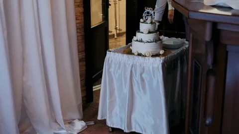 Taking out a cake in a restaurant on a wedding day. White three tiered cake Stock Footage 129149934