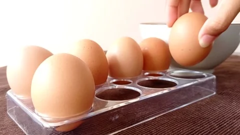 Taking out a chicken egg from its egg holder Stock Footage 145622040