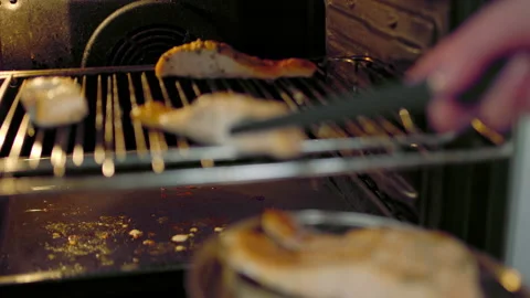 Taking out fillets of salmon in a silver plate from the grill in the oven. Stock Footage 132816269