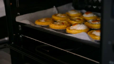 Taking out fresh made egg tarts from an oven Stock Footage 136204182