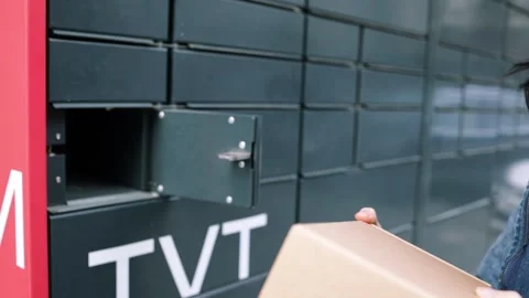 Taking out a parcel from a parcel locker. Woman receiving parcel Stock Footage 269983408