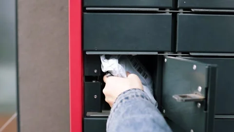 Taking out a parcel from a parcel locker. Woman receiving parcel Stock Footage 269983460