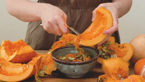 Taking out pumpkin seeds from fresh row orange pumpkin. Stock Footage 149385309