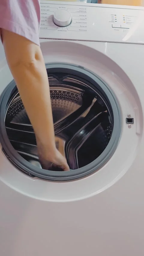 Taking out wet laundry from a white front load washing machine Stock Footage 329268574