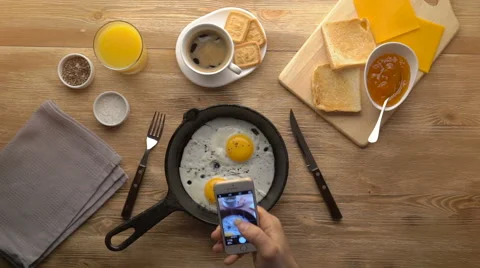 Taking picture of fried eggs with mobile phone. Phone in male hands. Top view Stock Footage 67535271