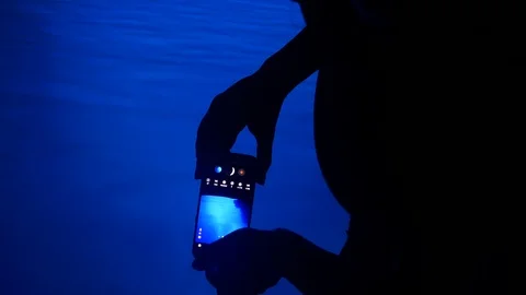 Taking picture with a mobile phone inside the blue cave Stock Footage 92103706