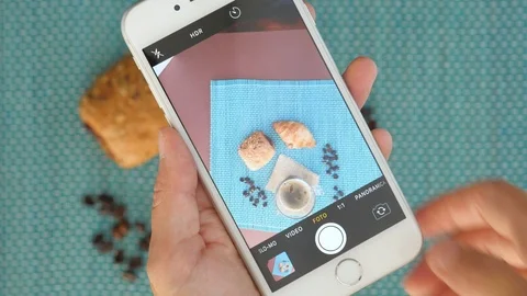 Taking picture with smartphone of breakfast table. glass cup of hot coffee and c Stock Footage 117134202