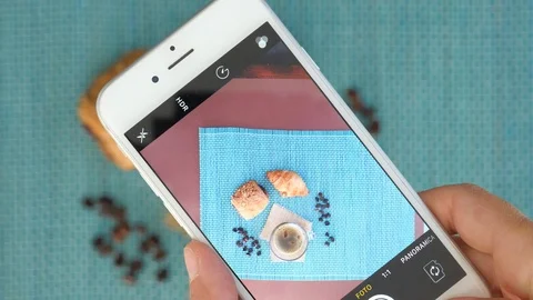 Taking picture with smartphone of breakfast table. glass cup of hot coffee and c Stock Footage 117134318
