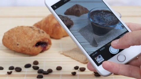 Taking picture with smartphone of breakfast table. glass cup of hot coffee and c Stock Footage 117134358