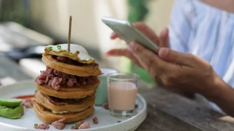 Taking pictures of a stack of pancakes with a poached egg. Stock Footage 269514763