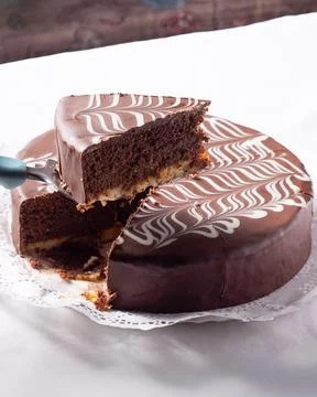 Taking a piece of chocolate cake off the table Fotos de archivo