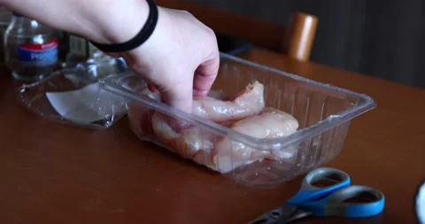 Taking a piece of raw meat from a plastic container and putting it on a woode Stock Footage 150206082
