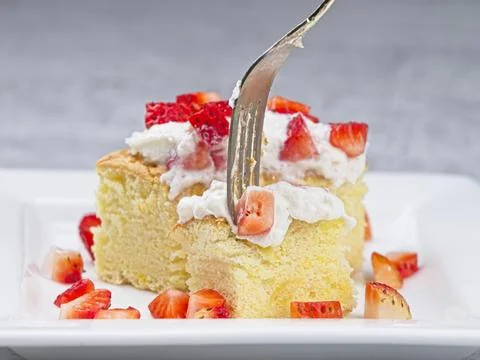 Taking a piece of sponge cake. Stock Photos