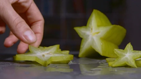 Taking a piece of starfruit with seeds. Prepare for cooking dessert, hand takes Stock Footage 125639331