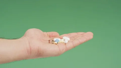 Taking a pill from a hand with various meds Stock Footage 99750495