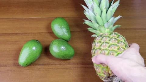 Taking pineapple from the table full of avocados 스톡 동영상 184599264