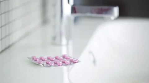 Taking pink pills in the bathroom Stock Footage 60406733