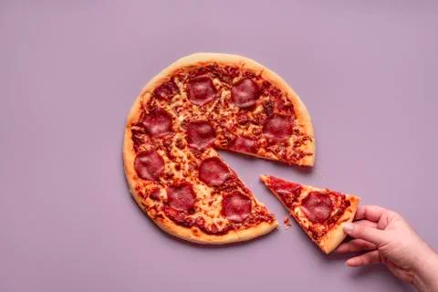 Taking pizza slice. Eating pizza pepperoni. Hot italian pizza Stock Photos
