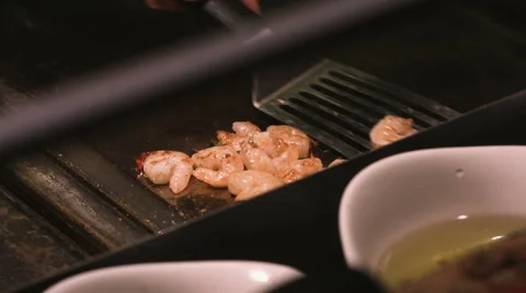 Taking prepared prawns off the pan with a metal spatula Stock Footage 65559270