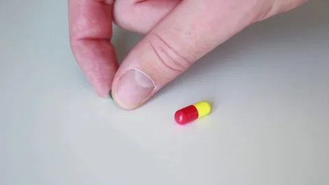 Taking a right pill from the white surface 動画素材 79589894